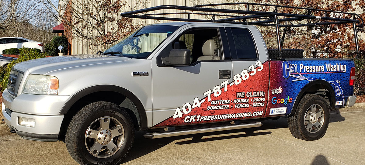 Silver CK1 Pressure Washing pickup with a red and blue partial wrap.